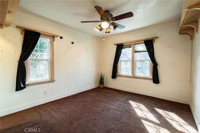 carpeted spare room featuring ceiling fan and a textured ceiling