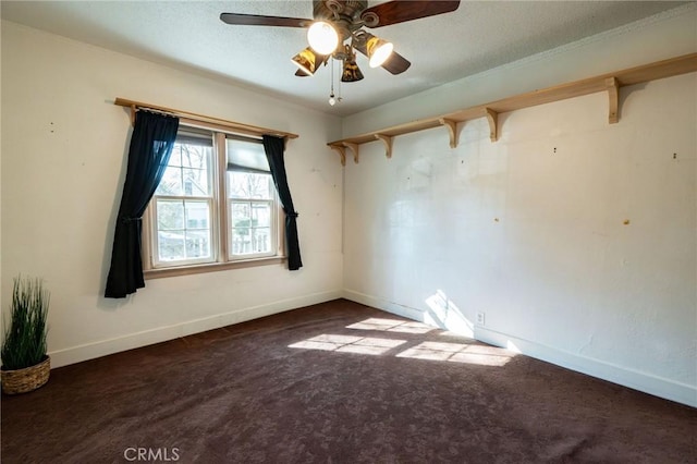 empty room with dark carpet and ceiling fan