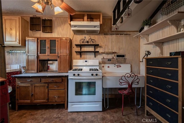 kitchen featuring a textured ceiling, white gas range oven, and ceiling fan