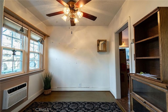 interior space featuring crown molding, dark hardwood / wood-style floors, ceiling fan, and a wall unit AC