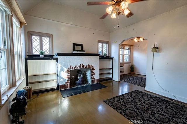 living room featuring hardwood / wood-style flooring, lofted ceiling, a healthy amount of sunlight, and a fireplace