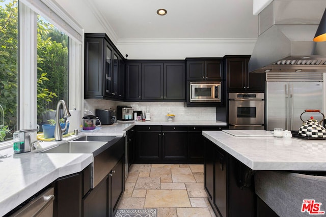 kitchen featuring island range hood, sink, backsplash, ornamental molding, and built in appliances