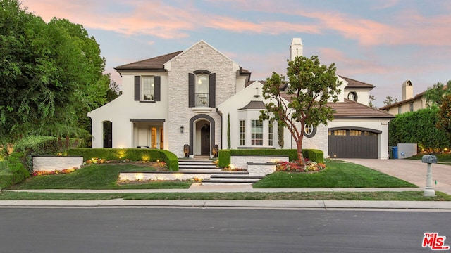 view of front of home with a garage and a yard