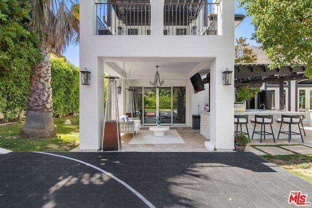 view of patio with an outdoor bar and a balcony