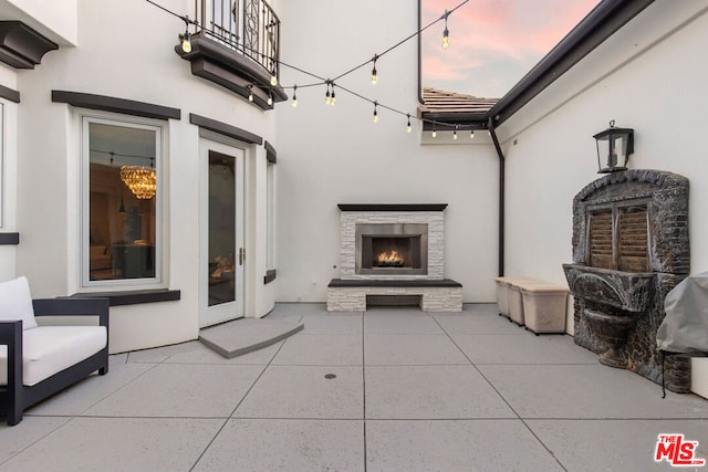 patio terrace at dusk with an outdoor stone fireplace