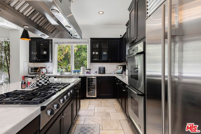 kitchen featuring appliances with stainless steel finishes, tasteful backsplash, ventilation hood, ornamental molding, and beverage cooler