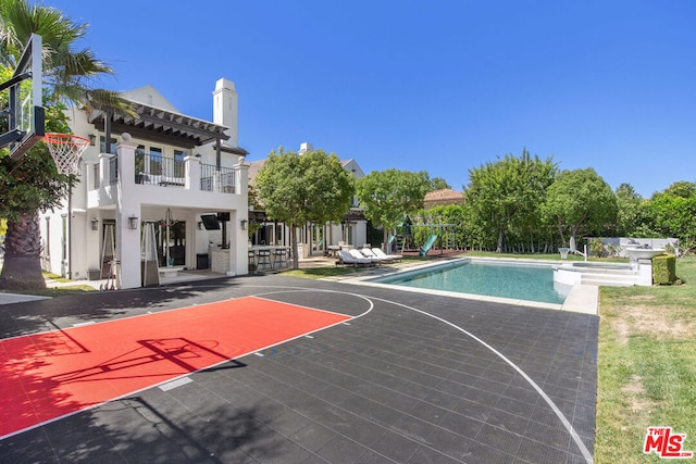 view of sport court with a fenced in pool and a pergola