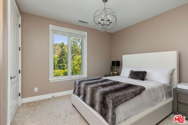 carpeted bedroom with an inviting chandelier