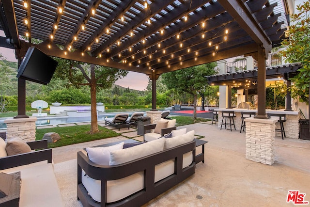 view of patio / terrace featuring a bar, an outdoor hangout area, and a pergola