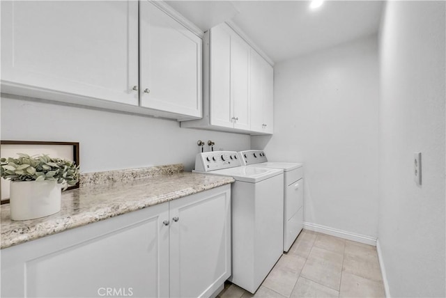 laundry room with cabinets, washer and dryer, and light tile patterned floors