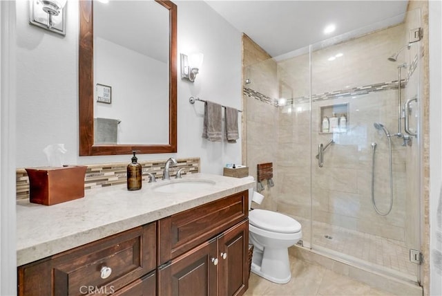 bathroom featuring tile patterned flooring, vanity, a shower with shower door, and toilet