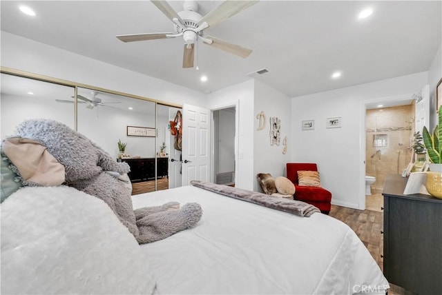 bedroom featuring connected bathroom, dark wood-type flooring, a closet, and ceiling fan