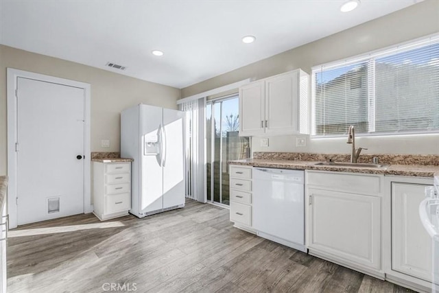 kitchen featuring sink, white cabinets, white appliances, and light wood-type flooring