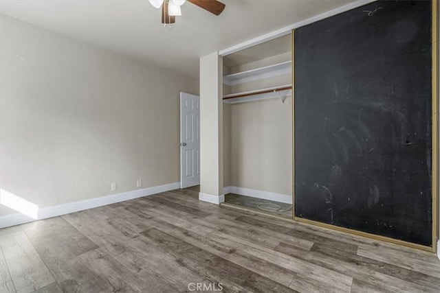 unfurnished bedroom with hardwood / wood-style flooring, ceiling fan, and a closet