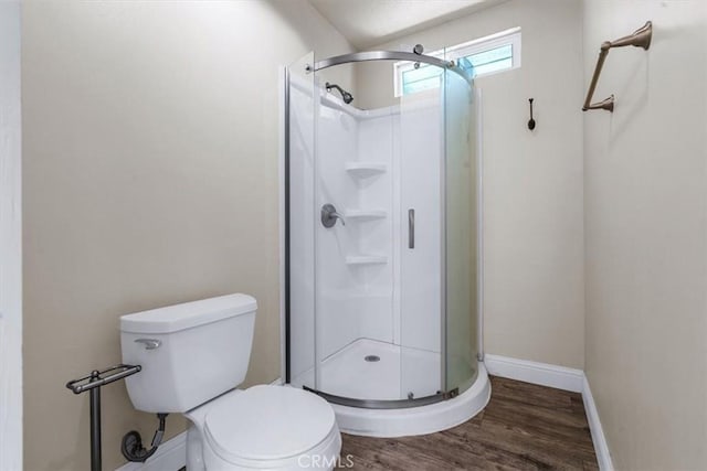 bathroom with a shower with door, hardwood / wood-style flooring, and toilet