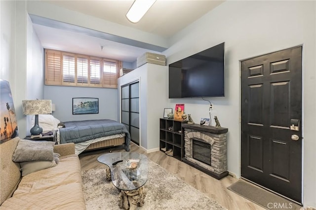 bedroom featuring a fireplace and light hardwood / wood-style flooring