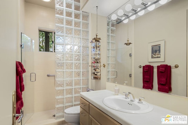 bathroom featuring vanity, toilet, and a tile shower