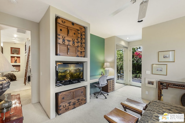 office featuring ceiling fan, light colored carpet, and built in desk