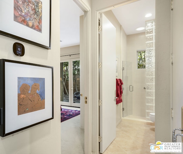 hallway featuring french doors, plenty of natural light, and light tile patterned floors