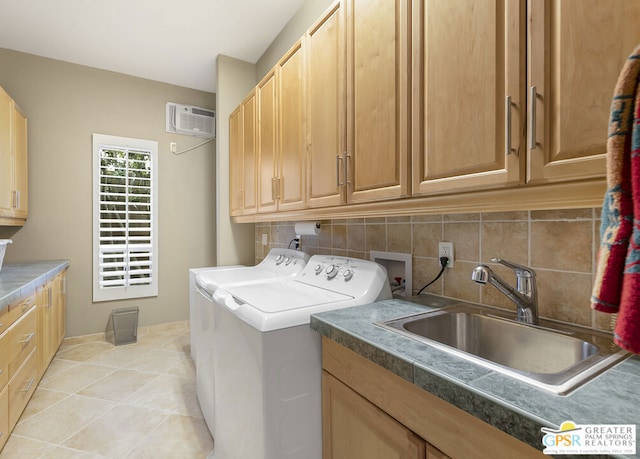 laundry area featuring sink, cabinets, a wall mounted AC, washer and dryer, and light tile patterned floors