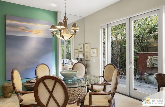 dining room featuring light tile patterned floors, an inviting chandelier, and french doors