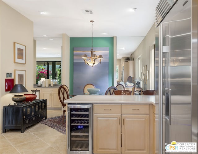 kitchen featuring light tile patterned floors, wine cooler, decorative light fixtures, high end refrigerator, and a chandelier