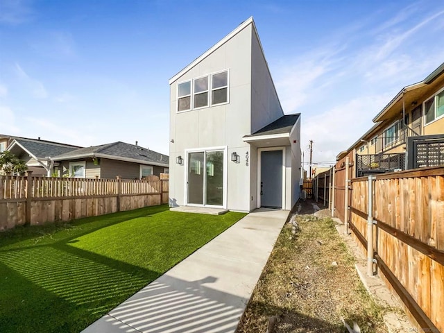 rear view of property featuring a yard