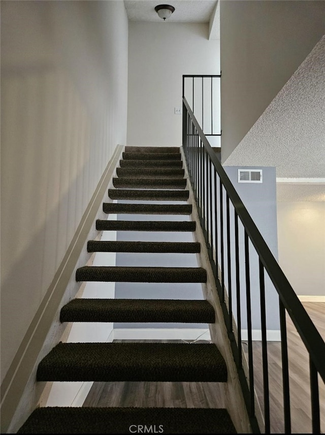 staircase with hardwood / wood-style flooring