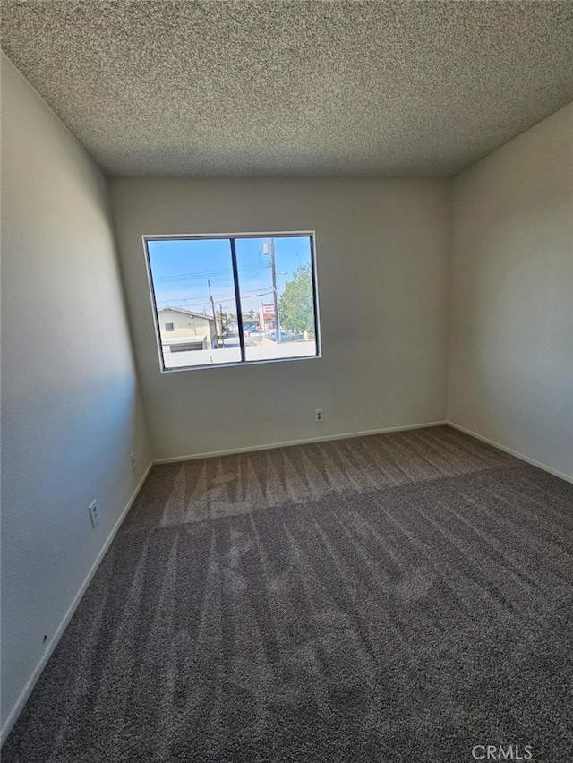 carpeted spare room featuring a textured ceiling