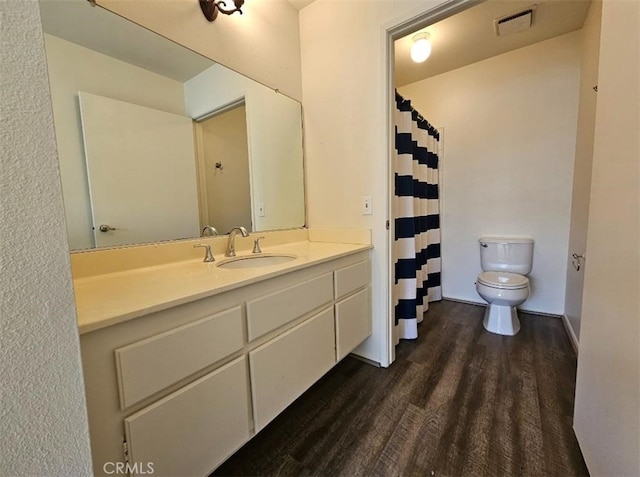 bathroom featuring vanity, toilet, and hardwood / wood-style floors