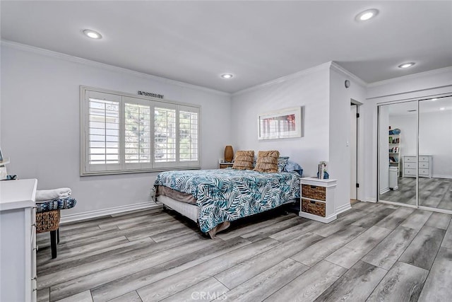 bedroom featuring ornamental molding, light wood-type flooring, and a closet