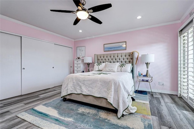 bedroom featuring ornamental molding, hardwood / wood-style floors, ceiling fan, and a closet