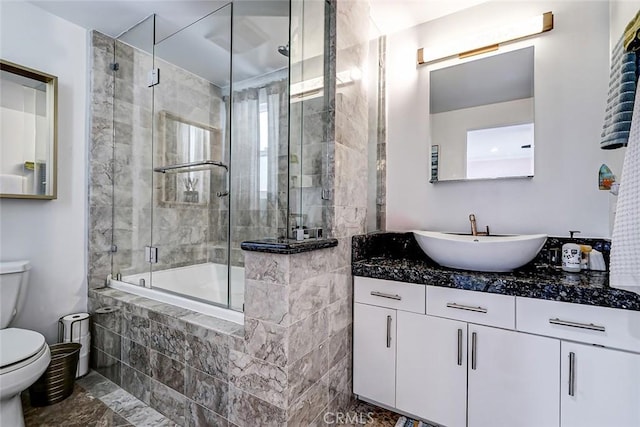 bathroom with tiled shower / bath, toilet, and vanity