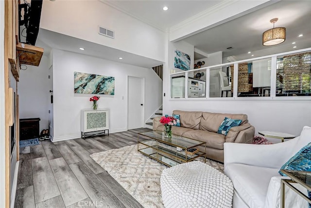 living area featuring crown molding, stairway, visible vents, recessed lighting, and wood finished floors