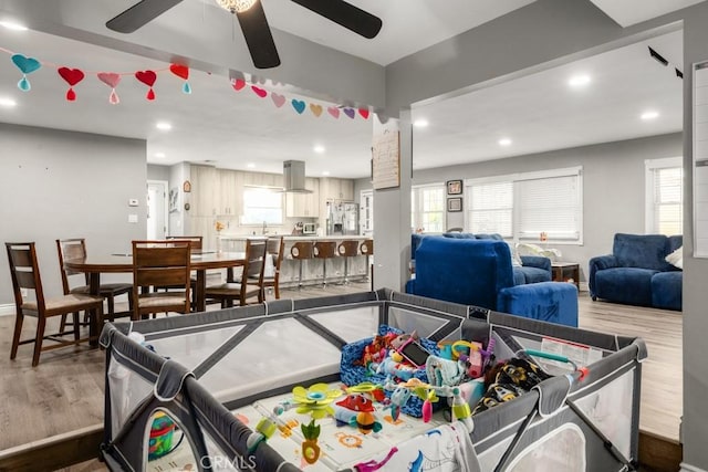 rec room featuring wood-type flooring, plenty of natural light, and ceiling fan