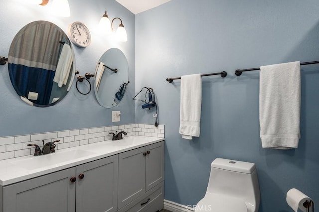 bathroom featuring tasteful backsplash, vanity, and toilet