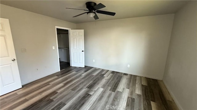 unfurnished bedroom with dark wood-type flooring, ceiling fan, and a closet