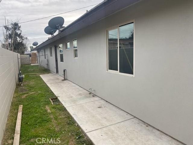 view of side of property with a patio and a yard