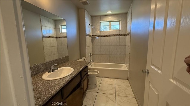 full bathroom with tiled shower / bath, a healthy amount of sunlight, toilet, and vanity