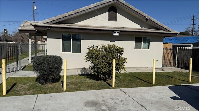 view of side of home featuring a patio area and a lawn