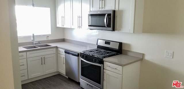 kitchen with white cabinetry, stainless steel appliances, dark wood-type flooring, and sink