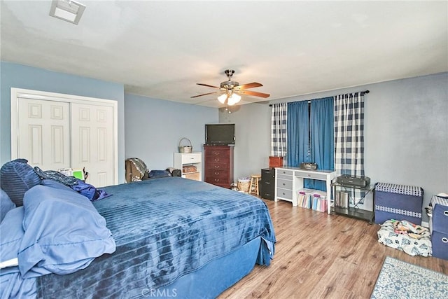 bedroom featuring hardwood / wood-style flooring, ceiling fan, and a closet