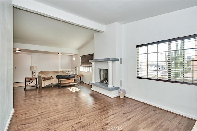 living room with hardwood / wood-style floors and vaulted ceiling with beams