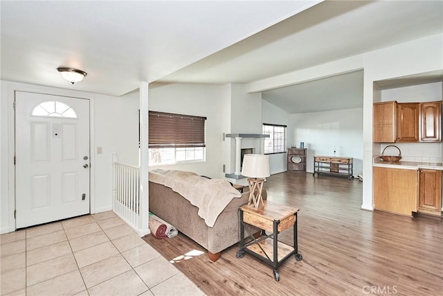 entrance foyer with light hardwood / wood-style flooring and vaulted ceiling