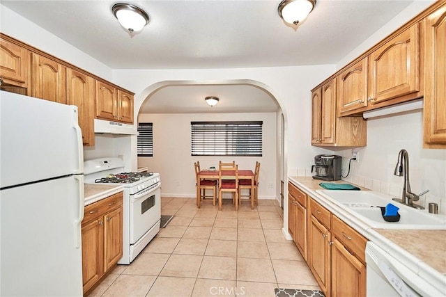 kitchen featuring sink, light tile patterned floors, and white appliances