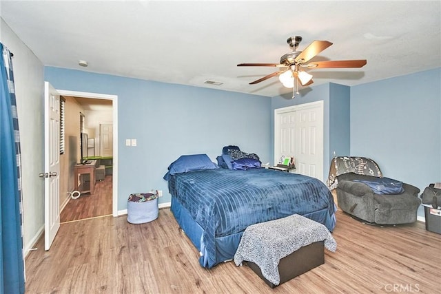 bedroom featuring ceiling fan, light hardwood / wood-style floors, and a closet