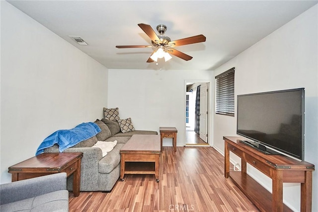 living room featuring light hardwood / wood-style flooring and ceiling fan