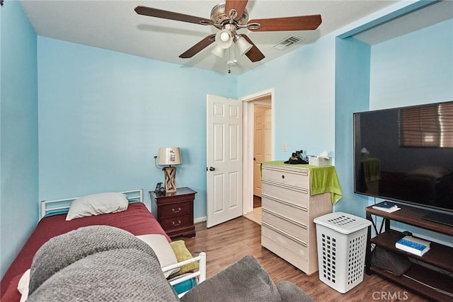 bedroom with dark hardwood / wood-style flooring and ceiling fan