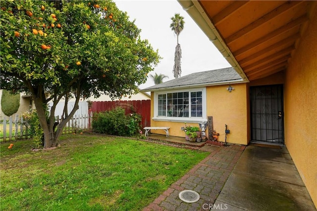 entrance to property featuring a patio area and a lawn