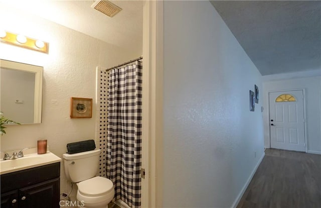 bathroom featuring hardwood / wood-style flooring, vanity, curtained shower, and toilet